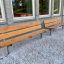 Bench, Steel Construction, wooden seating outside building on gravel