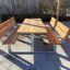 Wooden 'Table & Bench' set on a patio, perfect for outdoor seating.