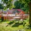 Benches and table in a playground area with red climbing frame.