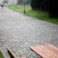 Wooden park table and bench on a cobblestone path.