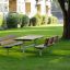 Table & Bench in a green park setting with trees and buildings in the background