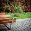 Table & Bench in a park setting with a background of green grass and autumn-colored foliage.