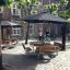 Table & Bench Quadro set in a courtyard under large black umbrellas.