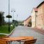 Table & Bench Quadro in a courtyard setting with buildings and lampposts.
