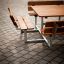 Outdoor Table & Bench Quadro set with wooden seats and metal frame on paved surface.
