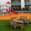 School Table & Bench in a playground setting with a slide and climbing structure in the background