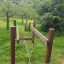 Wooden playground climbing structure for kids named Kongo in a green park setting.