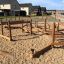 Outdoor wooden playground set Kongo on sandy area in residential neighborhood.