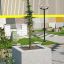 Concrete planter Berta with a growing tree in an outdoor display area.