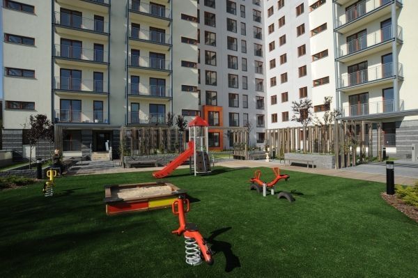Shock Absorbing Pad 45mm with artificial grass installed in a modern playground with various play eq