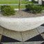 Large oval concrete planter Fossano with shrubs and small trees.