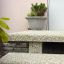 Concrete bench with Bell decorative planter on surface