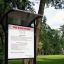 Park signboard for Kemi climbing structure with a roof and rules in a green park.