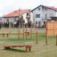 Outdoor playground equipment Double Somersault Nature in park setting with houses in background.