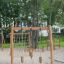 Lianes wooden playhouse in a playground with climbing nets and wooden posts