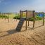 Lianes wooden playhouse on a sandy playground near the sea'