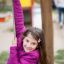 Girl playing on rope swing at Lianes wooden playhouse.