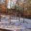 Diamond net playground equipment in a forest setting with autumn leaves.
