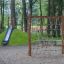 Butterfly climbing net in a playground with a slide in the background