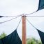 Sun Shades outdoor canopy with black fabric panels attached to a wooden pole.