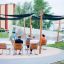 Sun Shades in a park providing shade for seated visitors with wooden benches.