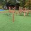 Playground climbing structure Sahara with wooden posts and ropes on artificial grass.