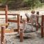 Children playing on Sahara wooden playground equipment with balancing bridge outdoors.