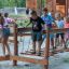 Children playing on Sahara wooden playground climbing bridge outdoors