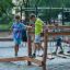 Children playing on Sahara wooden playground balance beam with chains outdoors.