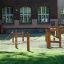 Gobi wooden playground climbing structure with ropes on grass in front of brick building