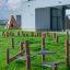 Wooden Gobi playground equipment on green lawn in front of modern school building.