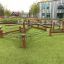 Outdoor play structure Gobi with wooden beams and rope elements on a school playground.