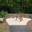 Tipi I climbing net in a landscaped play area with stone wall.