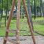 Wooden playground structure with climbing net for children.