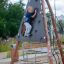 A child climbing on the Tipi II climbing net in a playground.