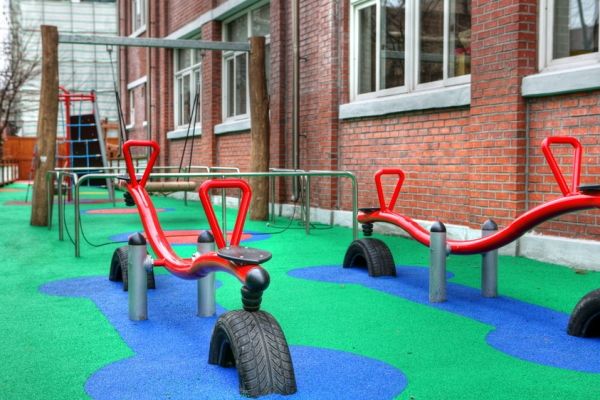 Playground with red seesaws on Wetpour 60 surface.