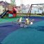 Playground with slides, swings, and play equipment on Wetpour 60 safety surface.