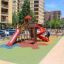 Colorful playground equipment on Wetpour 60 safety surface in an urban park.