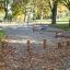 Outdoor playground featuring the Cape Code balance beam and stepping logs among trees in a park.