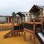 Knight's Castle Nature playhouse with slide on playground.