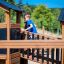 Child playing on the Knight's Castle Nature playhouse with slide.