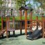 Fortress Nature playhouse with slide in an outdoor playground