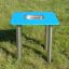 Sand & Water Table on green grass with blue surface and metal legs.