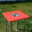 Sand & Water Table with red top and stainless steel basin standing on grass