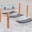Hammock playground equipment with wooden posts and black netting on sand surface