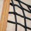 Wooden frame of a hammock with black rope netting.