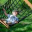 Black rope hammock with wooden frame on a playground
