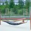 Hammock with wooden frame and black netting on playground.