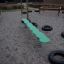 Wonderland Trim Trail obstacle course with green balance beam and tire steps in a playground setting