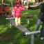 Child balancing on Wonderland Trim Trail beam in a playground.